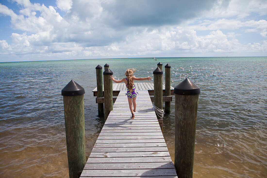 Caucasian girl walking on pier, Florida Keys, Florida, USA