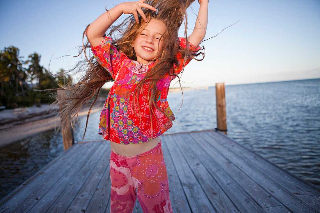 Caucasian girl dancing on pier, Florida Keys, Florida, USA