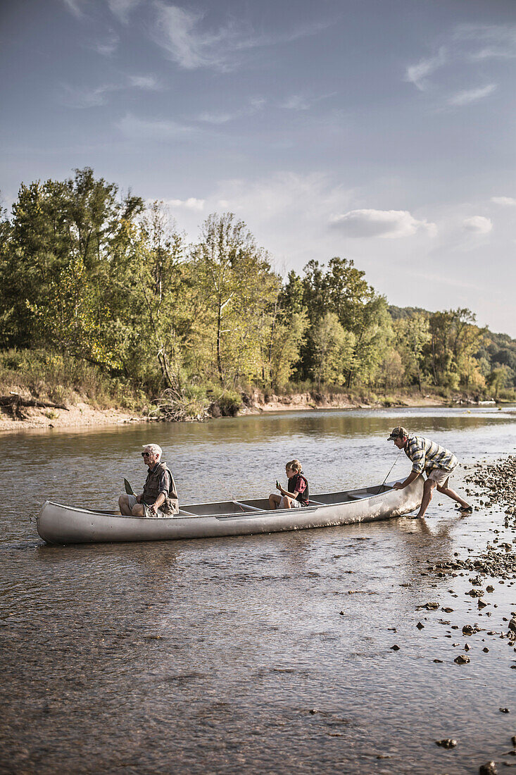 Three generations of Caucasian men in canoe on river, Saint Louis, Missouri, USA