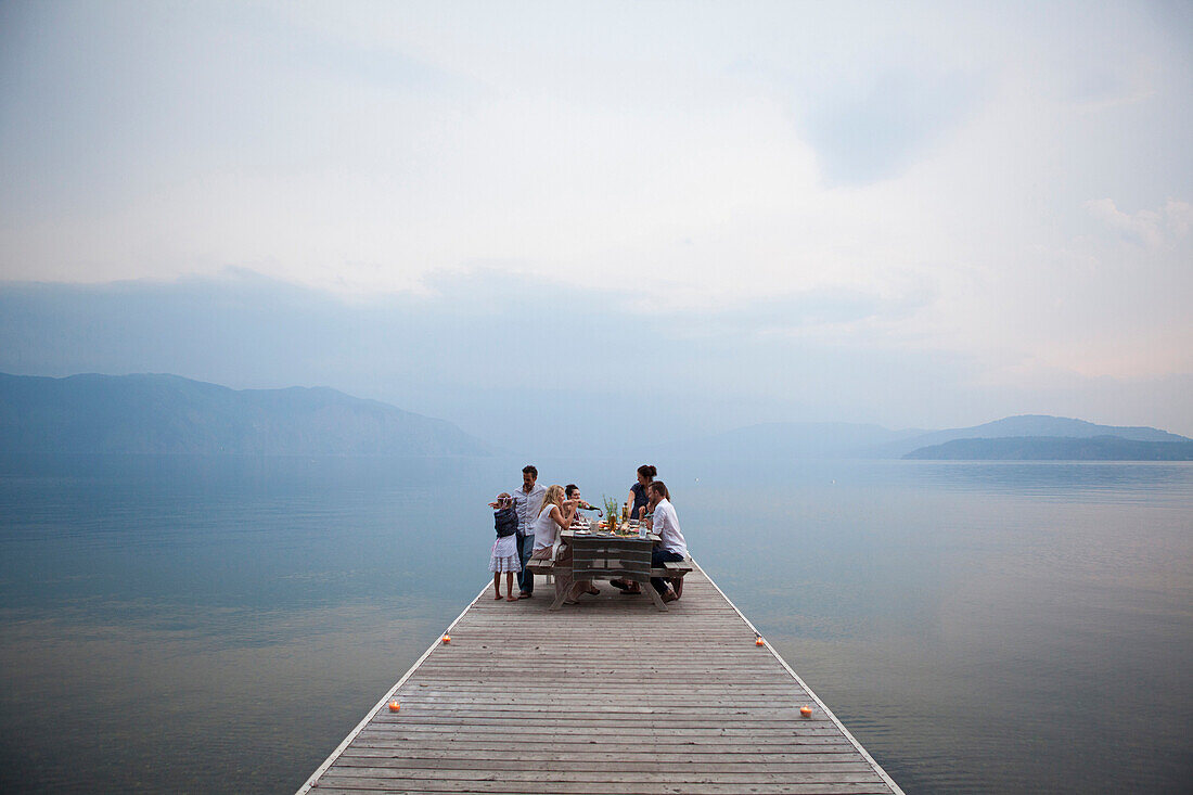 Caucasian family at picnic table on wooden dock over lake, Hope, Idaho, USA