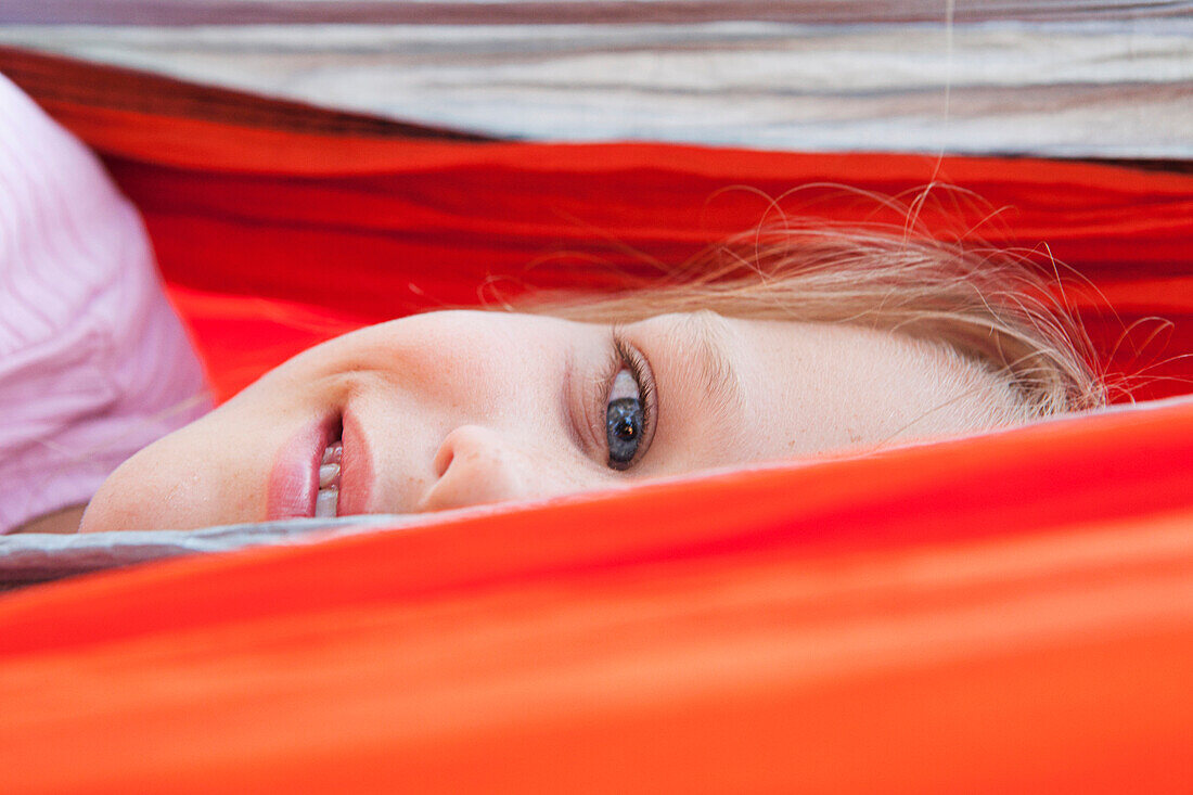 Close up of Caucasian girl peeking over hammock, Hope, Idaho, USA