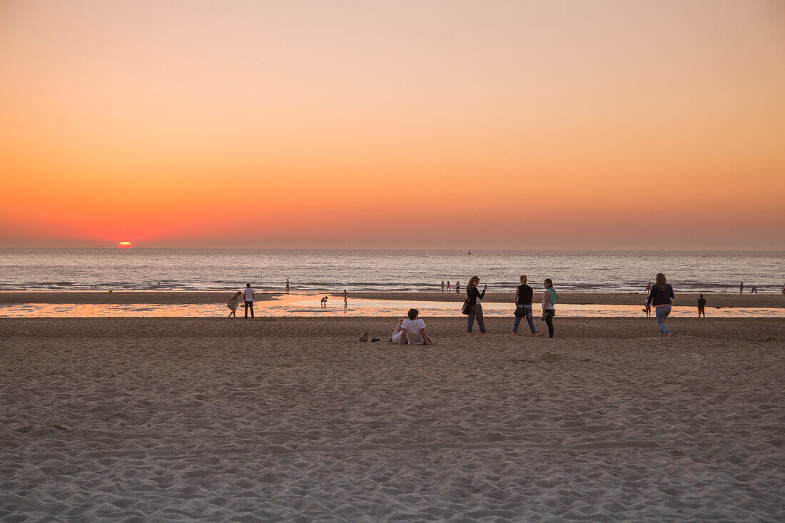 Menschen am Strand bei Sonnenuntergang, Ostende, Flandern, Belgien, Europa