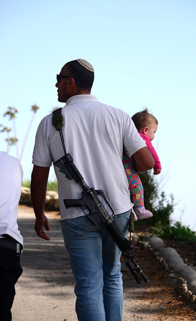 Israeli man carrying weapon and child, Israel
