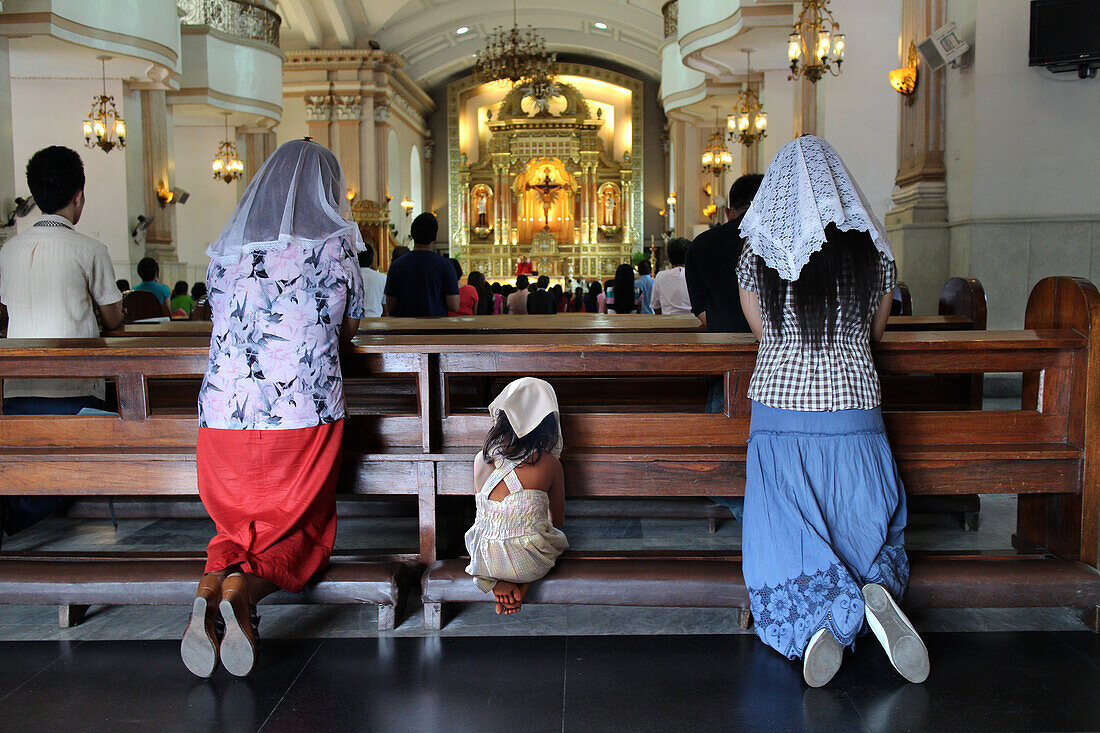 Frauen und Kind knien und beten, Kathedrale von Cebu, Philippinen, Asien