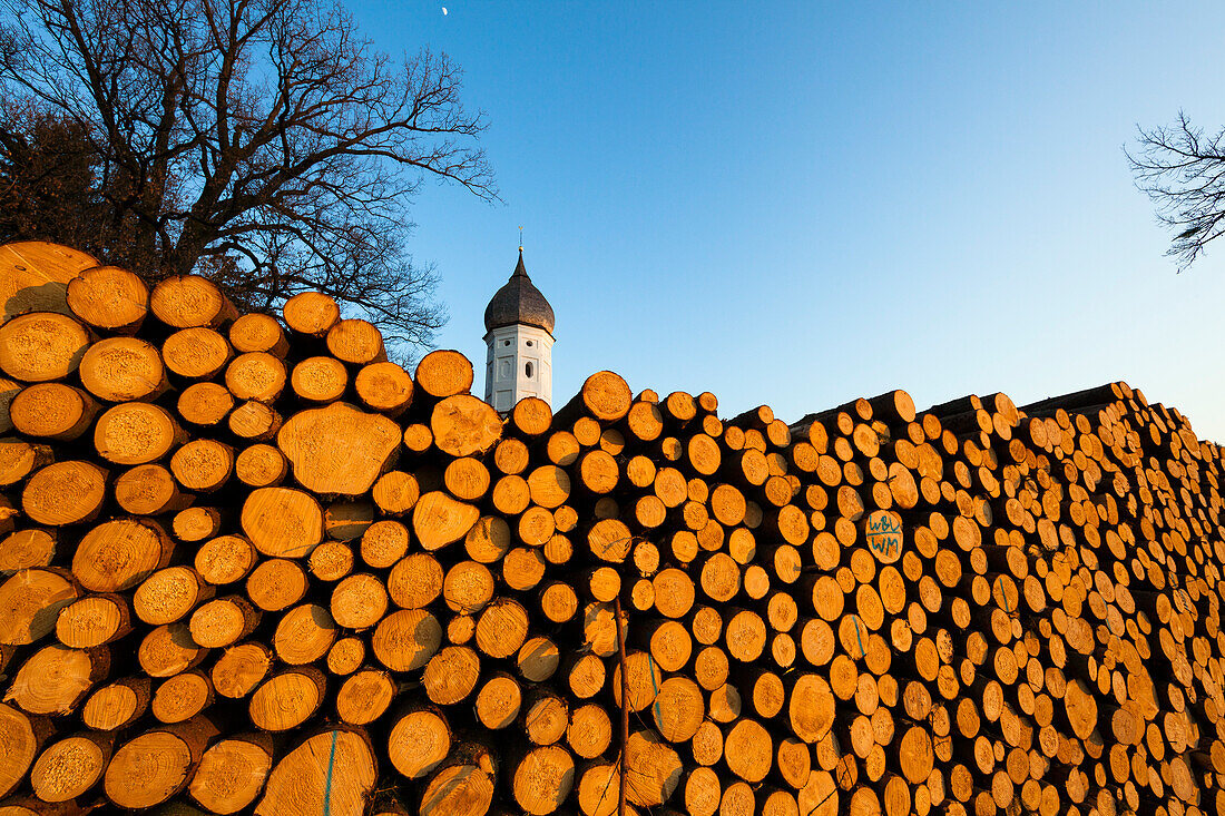 Holzstapel vor Kirche, Holzwirtschaft in Bayern, Penzberg, Oberbayern, Deutschland