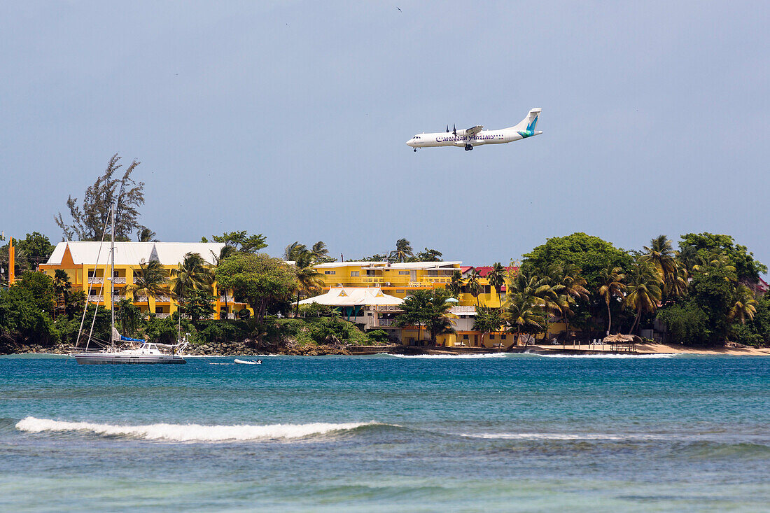 Flugzeug der Caribbean Airlines im Landeanflug über Hotelanlage, Crown Point tobago, West Indies