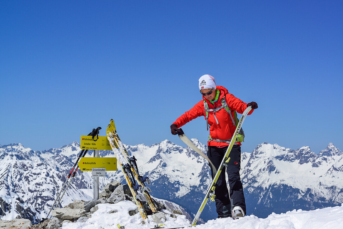 Frau auf Skitour steht im Scharnitzsattel und zieht Felle ab, Scharnitzsattel, Lechtaler Alpen, Tirol, Österreich