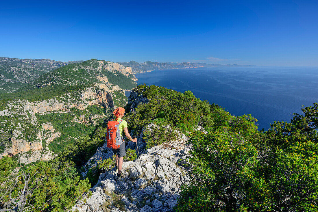 Woman hiking Selvaggio Blu on ridge with view to Mediterranean, Selvaggio Blu, National Park of the Bay of Orosei and Gennargentu, Sardinia, Italy