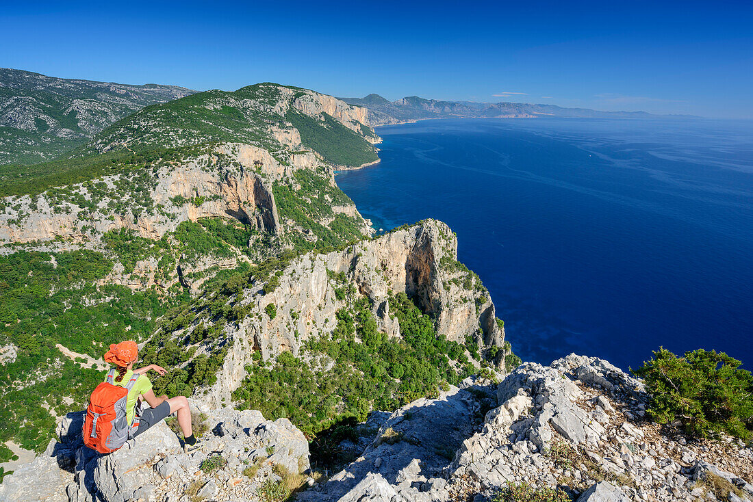 Frau sitzt am Selvaggio Blu und blickt auf Mittelmeer, Selvaggio Blu, Nationalpark Golfo di Orosei e del Gennargentu, Sardinien, Italien