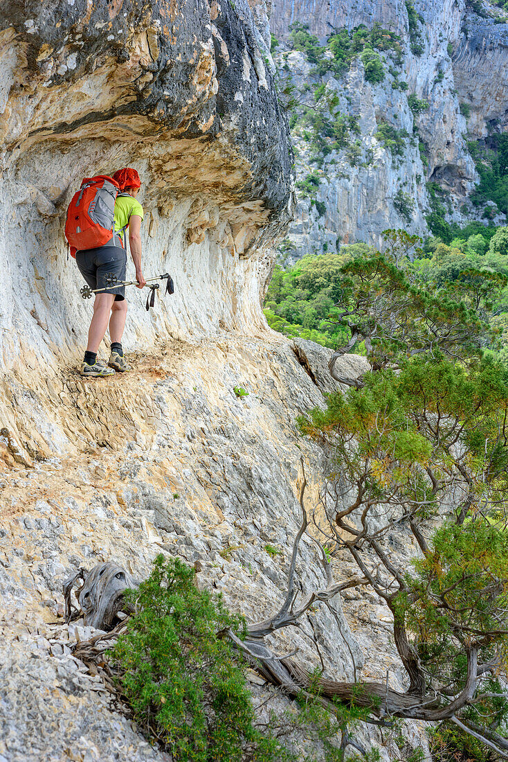 Frau wandert am Selvaggio Blu über Felsband, Selvaggio Blu, Nationalpark Golfo di Orosei e del Gennargentu, Sardinien, Italien