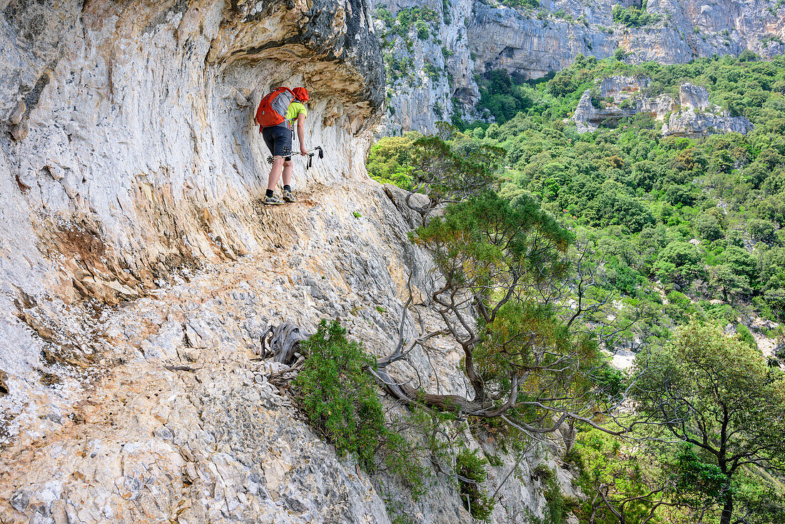 Frau wandert am Selvaggio Blu über Felsband, Selvaggio Blu, Nationalpark Golfo di Orosei e del Gennargentu, Sardinien, Italien