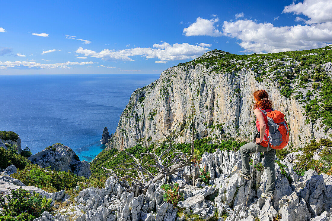 Frau beim Wandern blickt auf Küste am Golfo di Orosei mit Felsnadel Pedra Longa, Selvaggio Blu, Nationalpark Golfo di Orosei e del Gennargentu, Sardinien, Italien