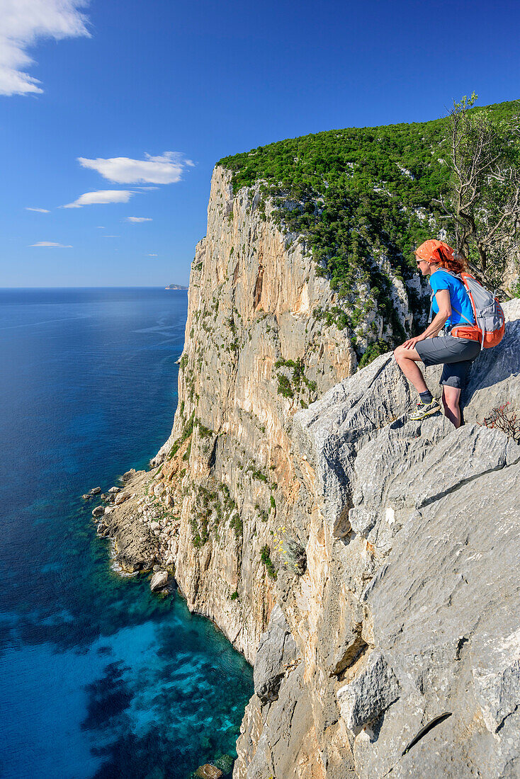 Frau beim Wandern blickt über Steilküste auf Golfo di Orosei, Selvaggio Blu, Nationalpark Golfo di Orosei e del Gennargentu, Sardinien, Italien