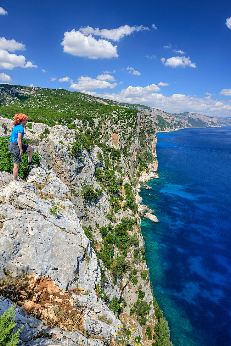 Frau beim Wandern blickt über Steilküste auf Golfo di Orosei, Selvaggio Blu, Nationalpark Golfo di Orosei e del Gennargentu, Sardinien, Italien