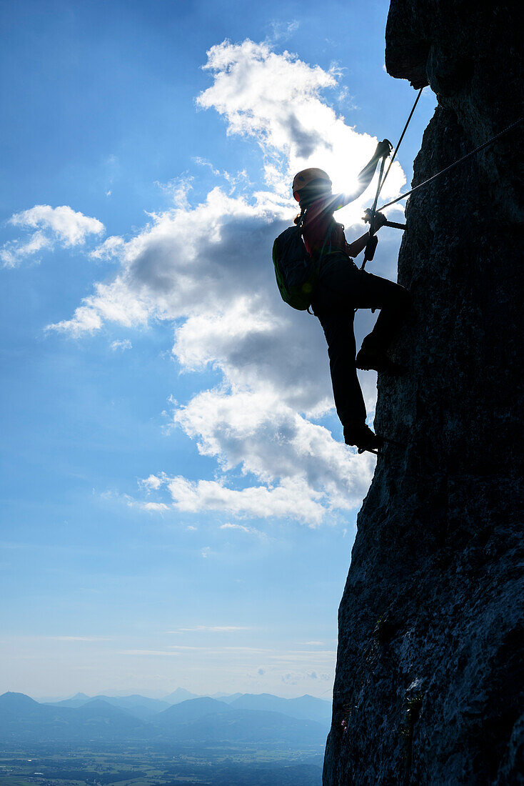 Woman ascending on steep fixed rope route, fixed rope route Pidinger Klettersteig, Hochstaufen, Chiemgau Alps, Chiemgau, Upper Bavaria, Bavaria, Germany