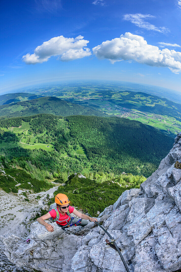 Woman ascending on fixed rope route, fixed rope route Pidinger Klettersteig, Hochstaufen, Chiemgau Alps, Chiemgau, Upper Bavaria, Bavaria, Germany