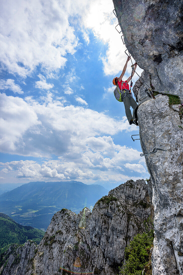 Woman ascending on steep fixed rope route, fixed rope route Pidinger Klettersteig, Hochstaufen, Chiemgau Alps, Chiemgau, Upper Bavaria, Bavaria, Germany