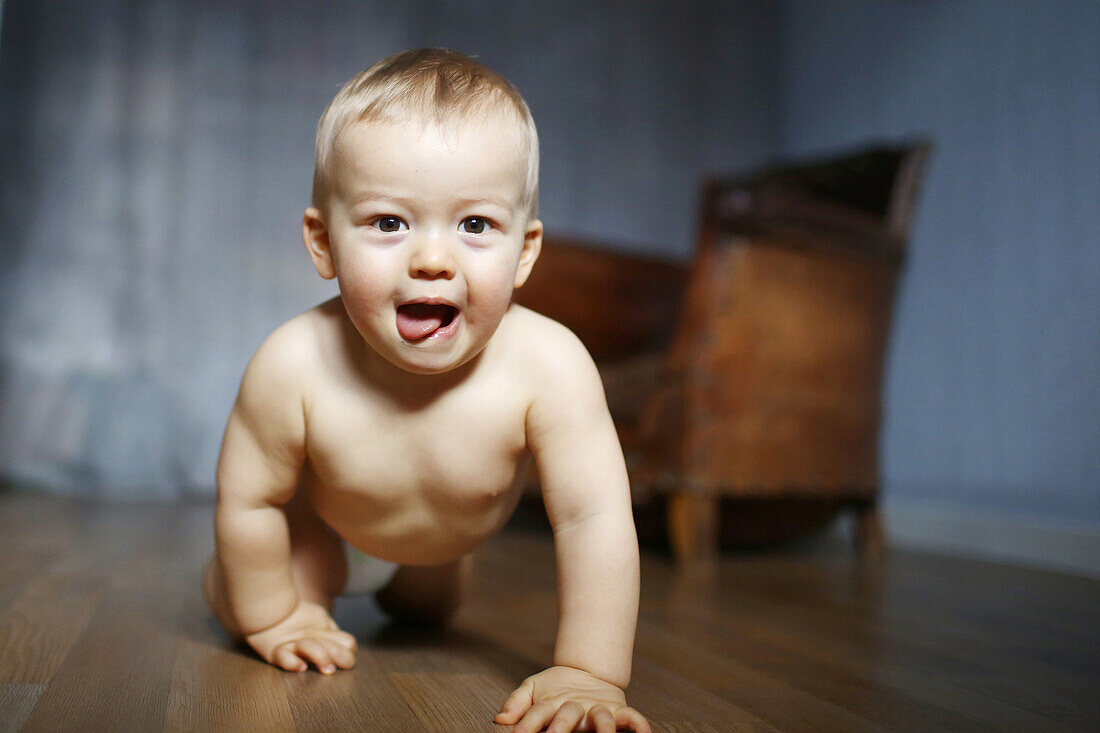 A baby boy crawling in his room