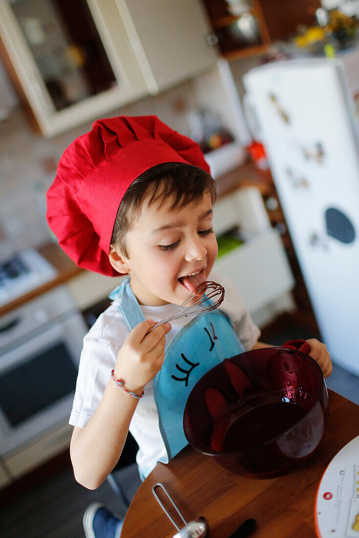 A little boy cooking a chocolate cake