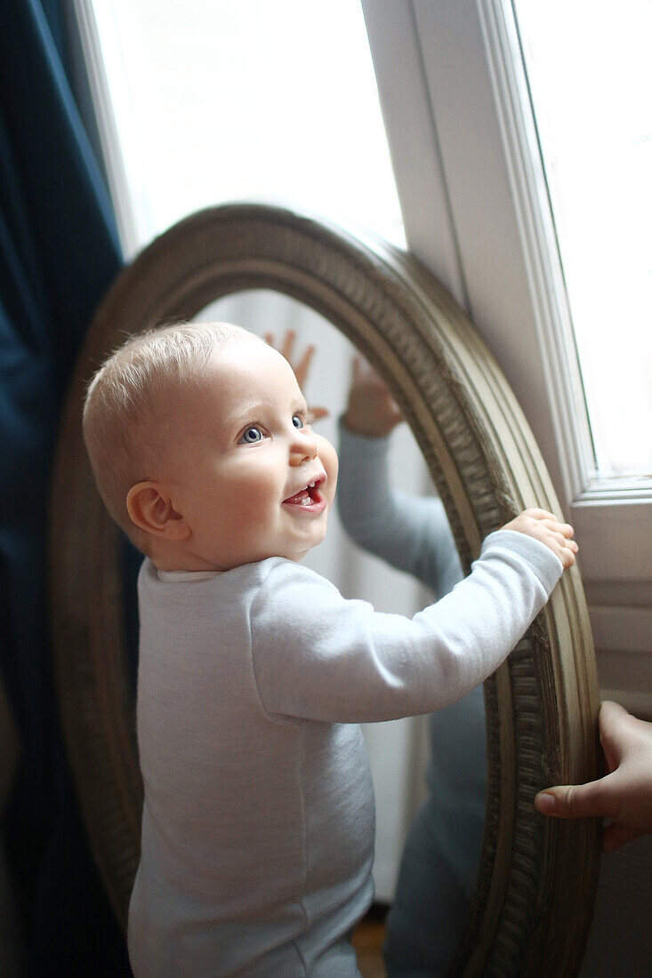 A 10 months baby boy in front of a mirror