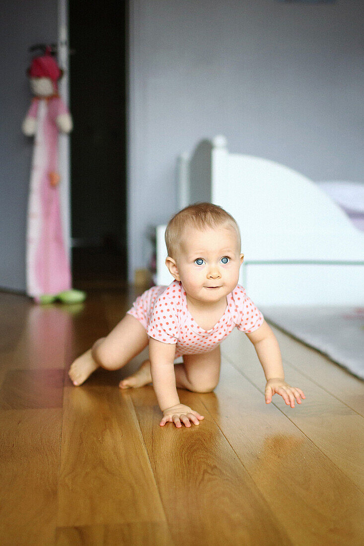 A baby girl walking with 4 legs in her room