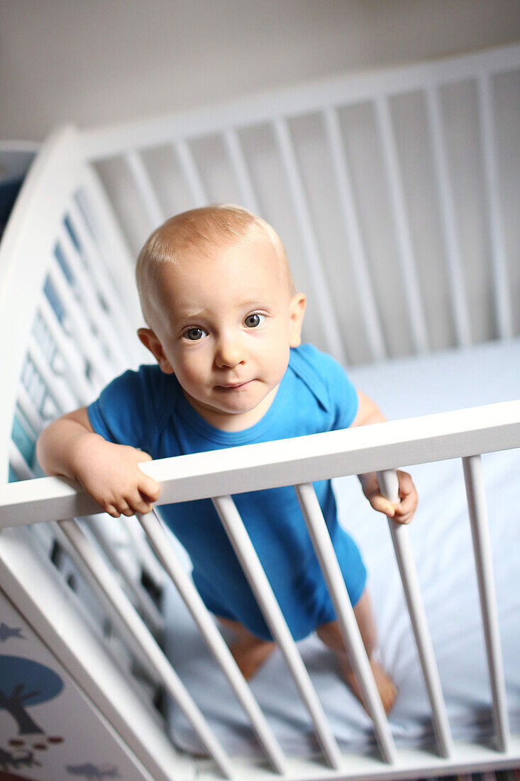 Baby boy standing in his crib