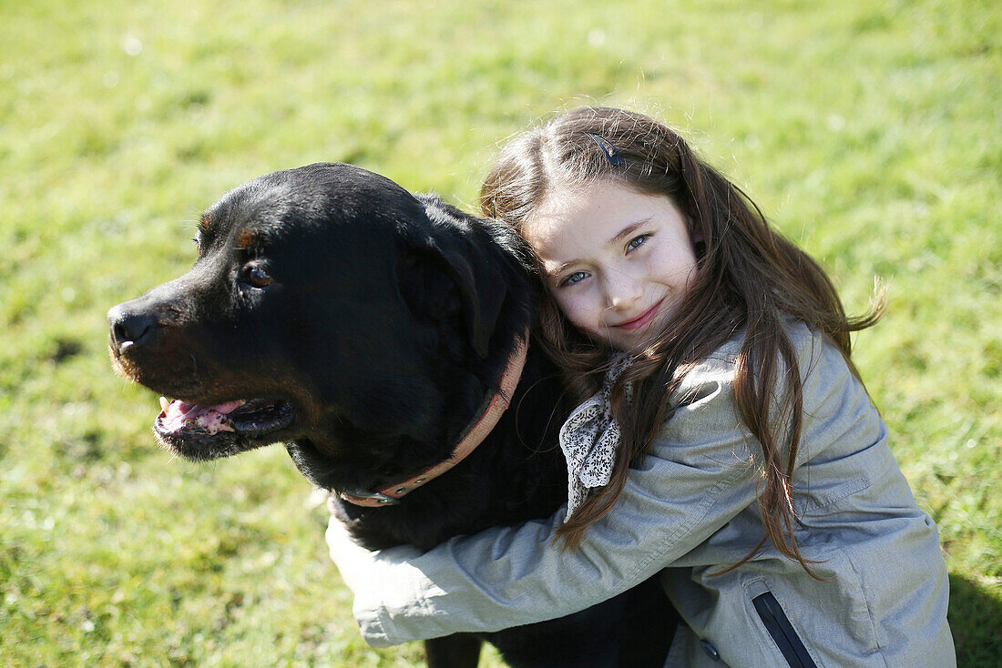 A 7 years old girl with her dog, a rottveiler