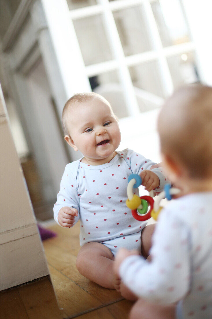 A 10 months baby girl in front of a mirror