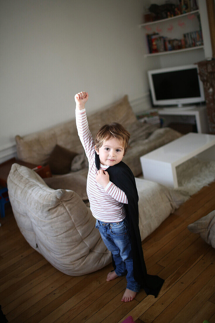 Little boy playing with a black cape