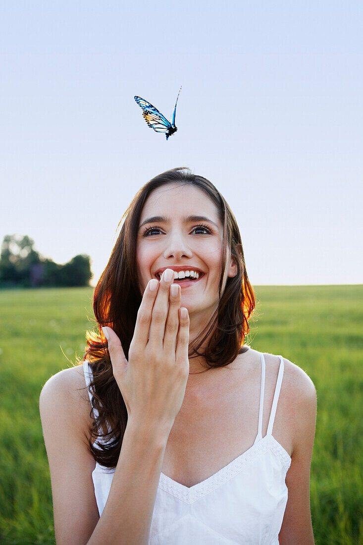 Woman watching butterfly in meadow