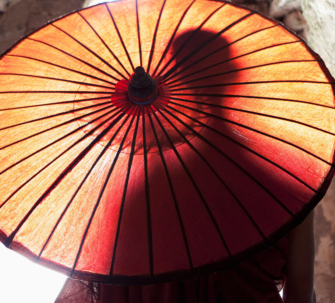 Silhouette of Asian man behind sun umbrella