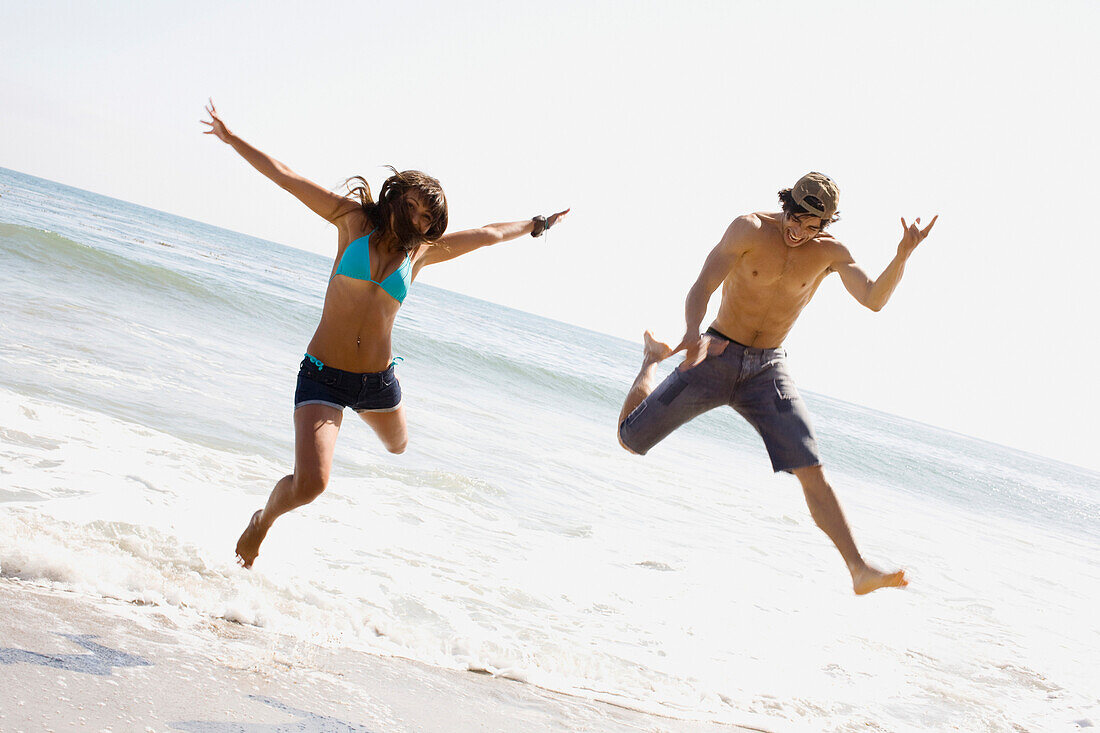 Couple jumping on beach together