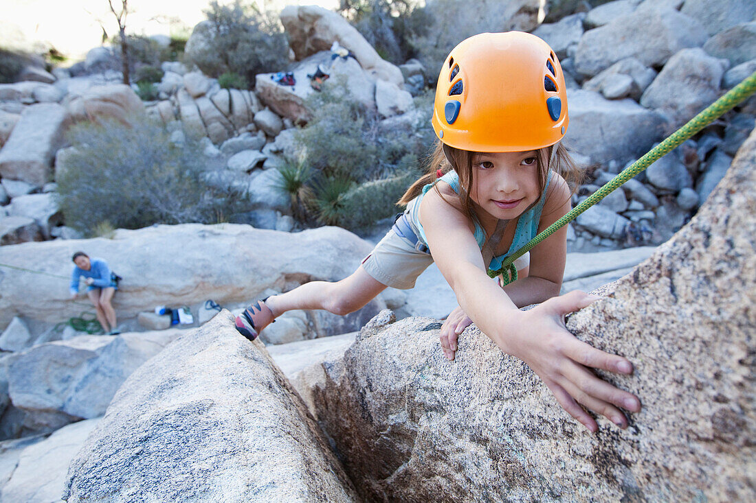 Mixed race girl rock climbing