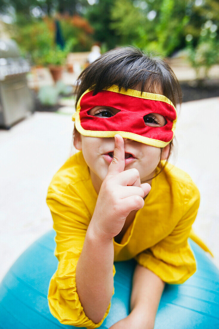 Mixed race girl wearing mask and gesturing