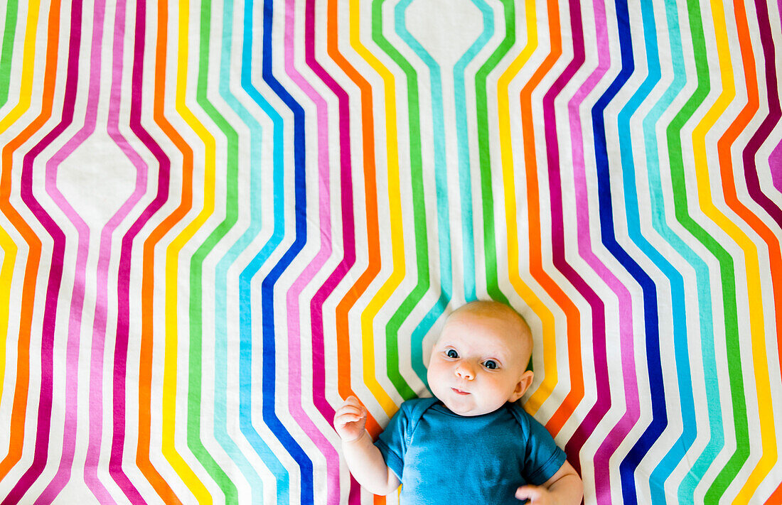 Baby Laying on Colorful Geometric Fabric, High Angle View