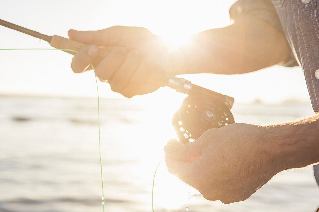 Man Fly-fishing, Close-Up of Hands and Reel
