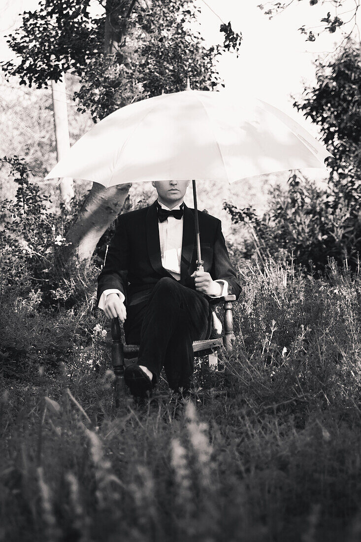 Seated Man in Tuxedo Holding Umbrella
