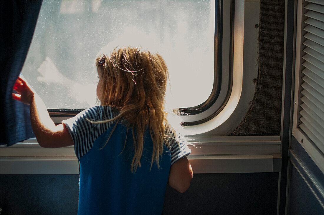 Young Girl Looking out Train Window