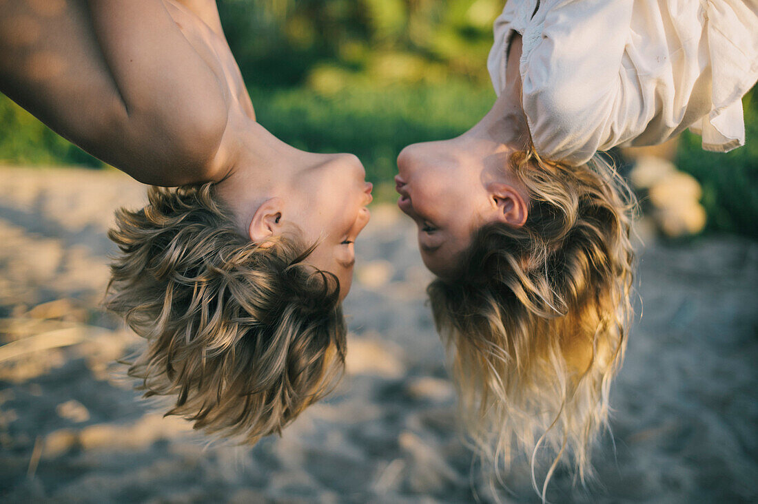 Young Boy and Girl Hanging Upside Down About to Kiss