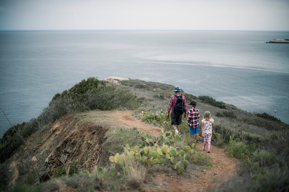 Father and Two Children on Trail on Coastal Cliff