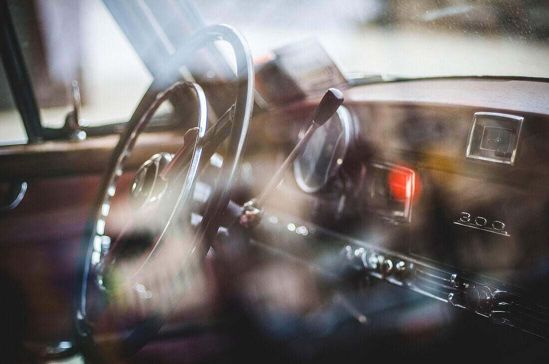 Steering Wheel and Dashboard of Vintage Mercedes Through Window and Reflections