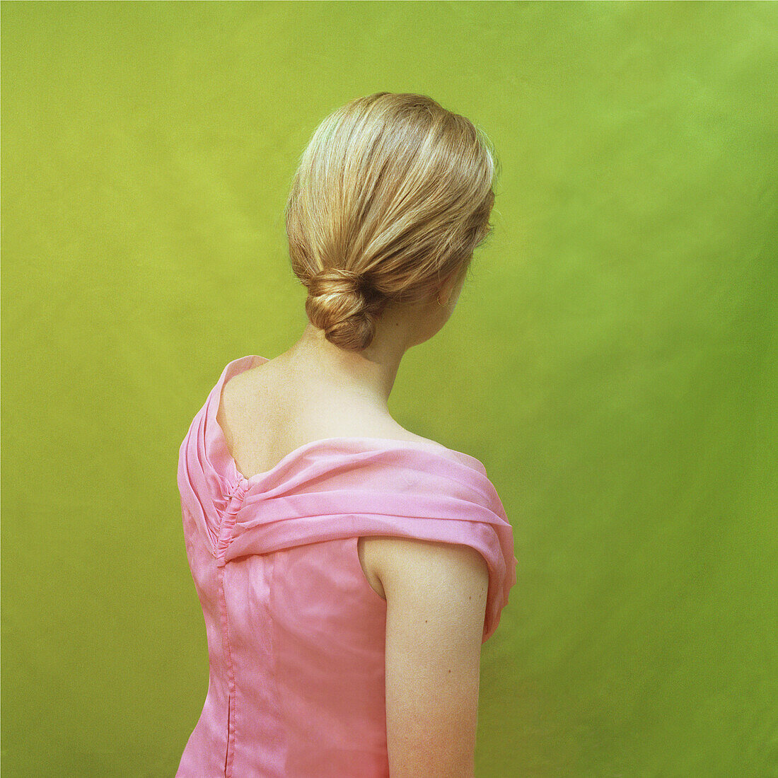 Blondes Teenager-Mädchen in rosa Kleid, Rückansicht