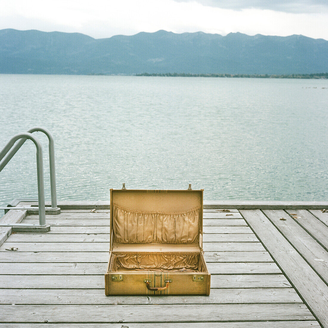 Open Suitcase on Dock with Lake in Background