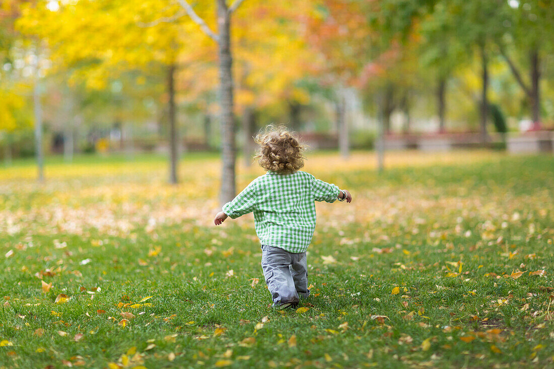 Caucasian boy running on grass lawn, Santa Fe, New Mexico, USA