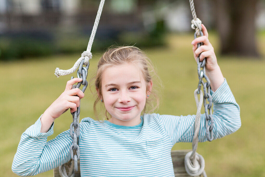 Caucasian girl smiling in swing, C1