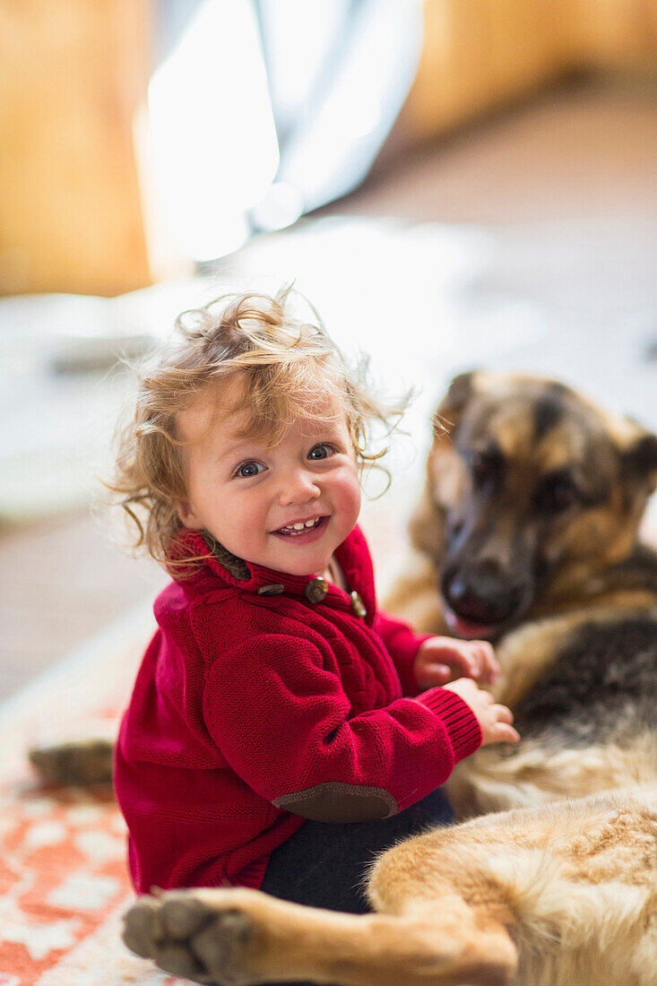 Caucasian baby boy playing with dog on floor, C1