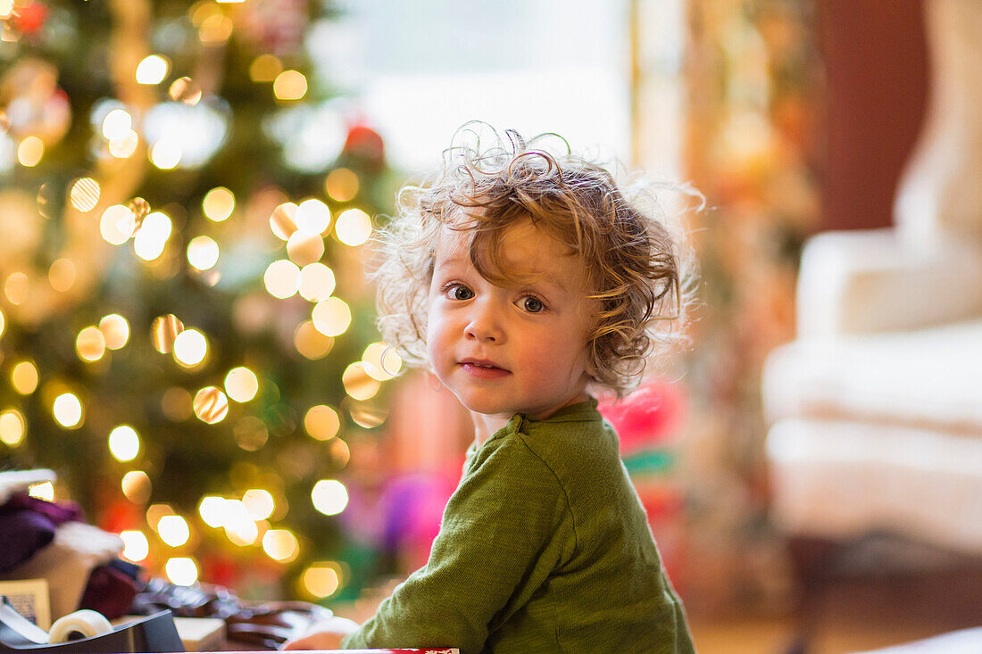 Caucasian baby boy sitting near Christmas tree, C1