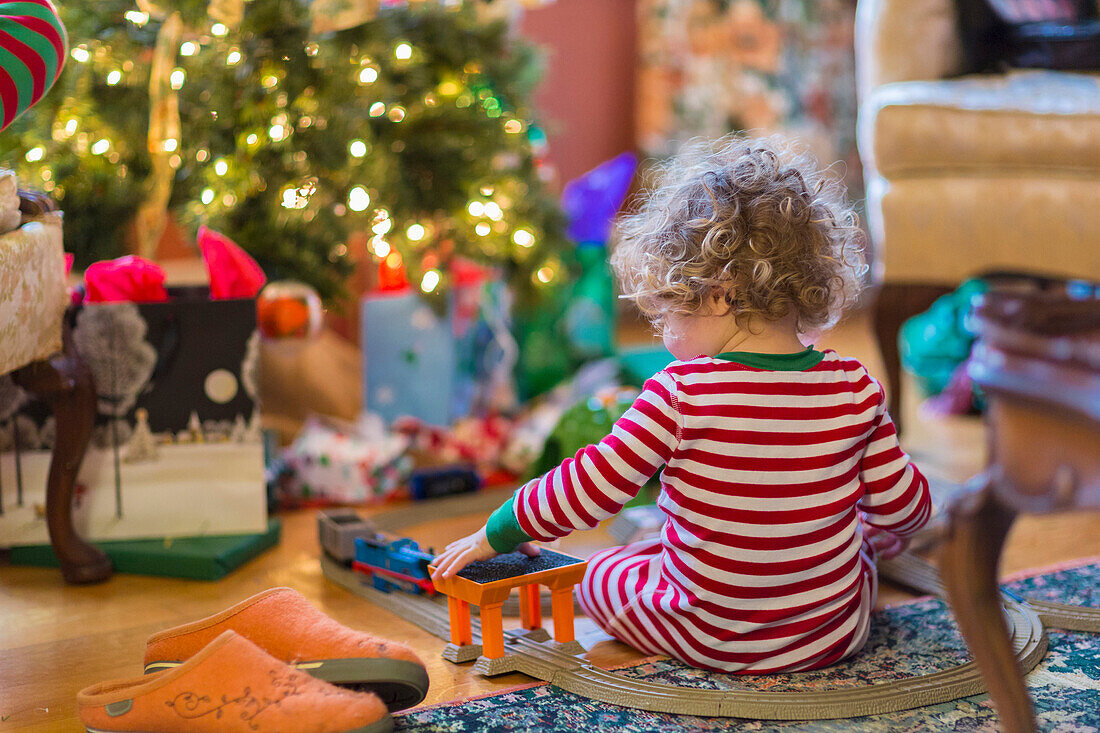 Caucasian baby boy playing with toys near Christmas tree, C1