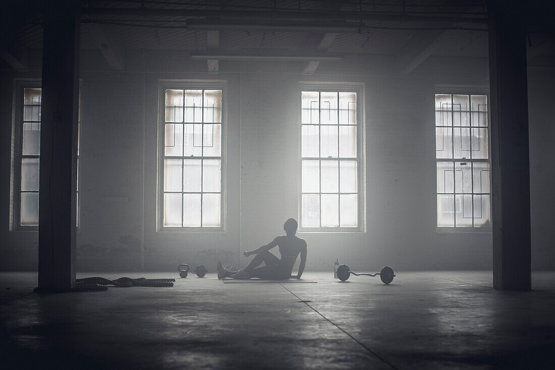 Black woman stretching in dark gym, Saint Louis, MO, USA
