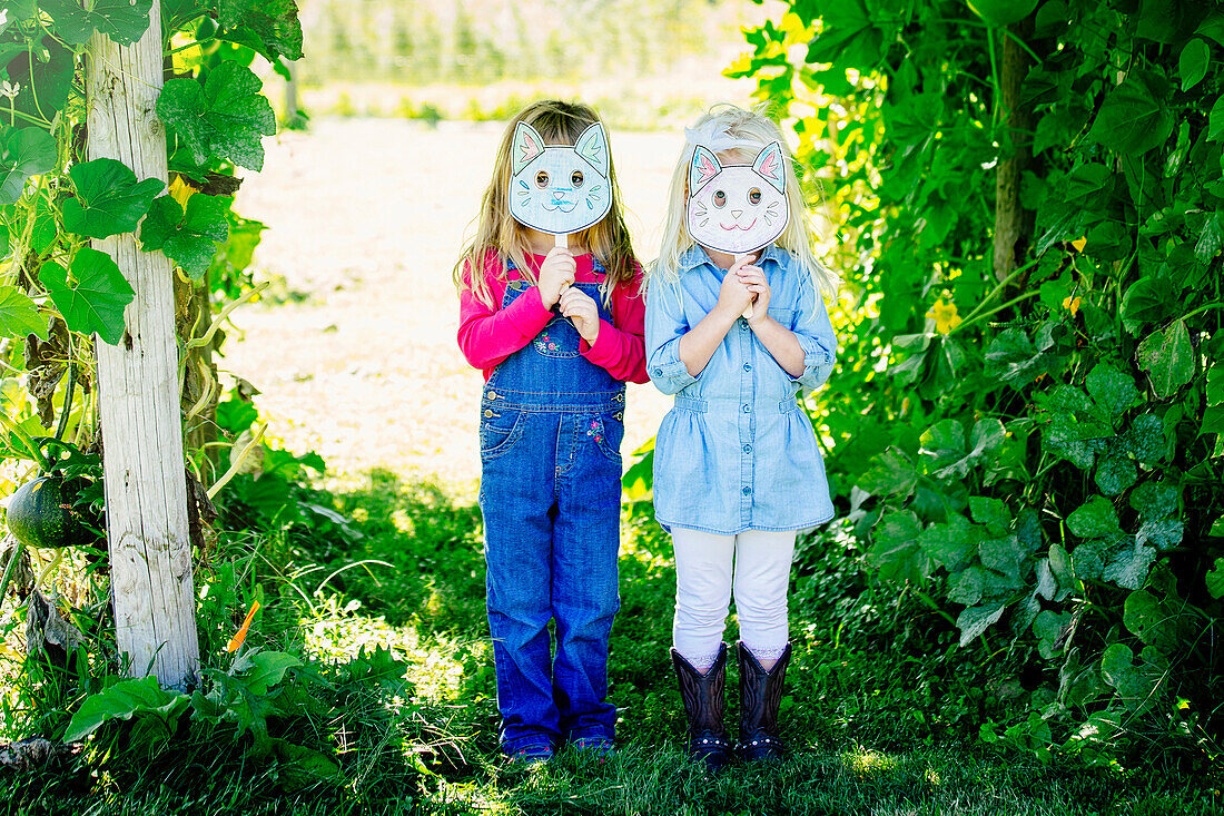 Caucasian girls holding cat mask, Omaha, Nebraska, USA